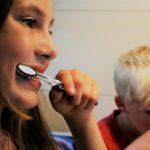 woman and kid brushing teeth