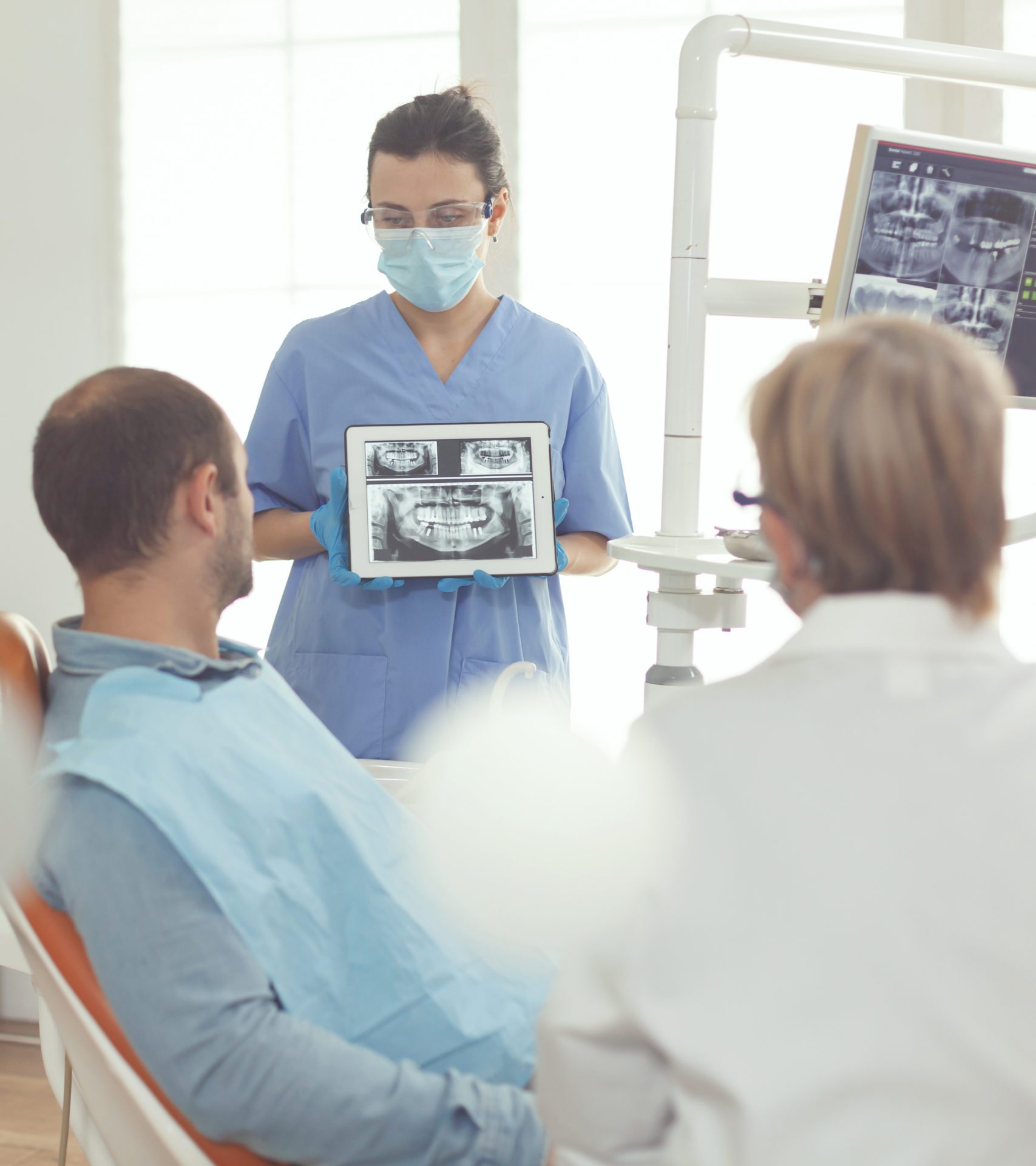 Orthodontist nurse holding digital tablet with tooth radiography on screen