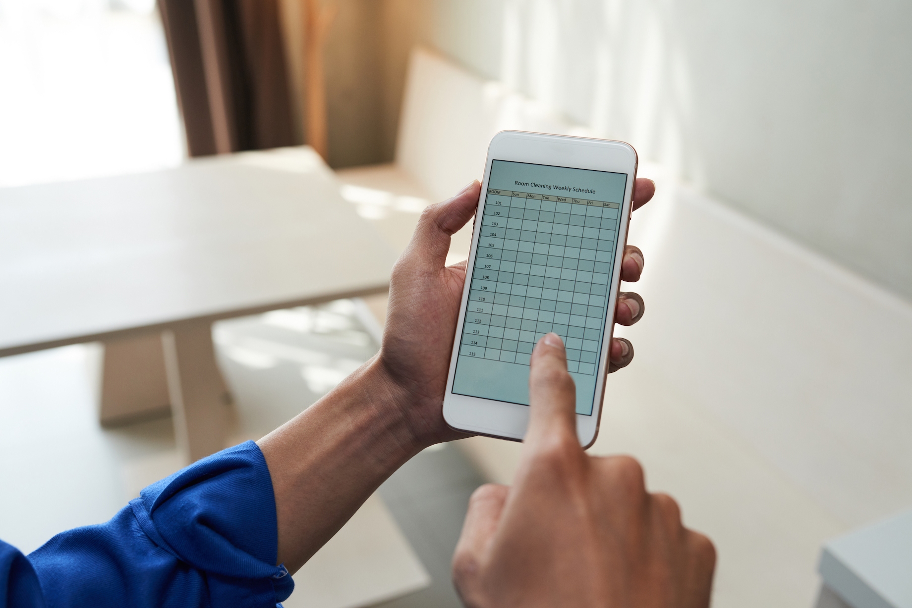 Service worker checking room cleaning weekly schedule on his smartphone