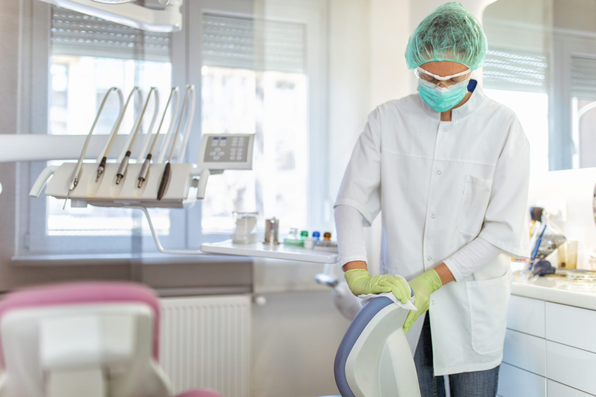 Female doctor cleaning dental office COVID cleaning