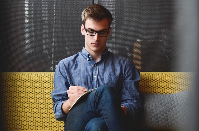 man sitting and writing